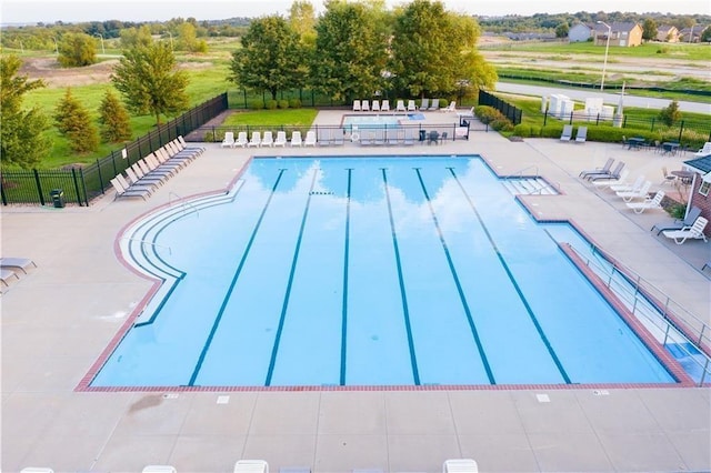 view of swimming pool featuring a patio area and fence