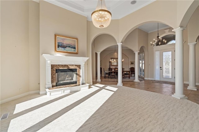 21111 W 95th Ter, Lenexa, KS 66220 - unfurnished living room with visible vents, arched walkways, decorative columns, a towering ceiling, and a notable chandelier
