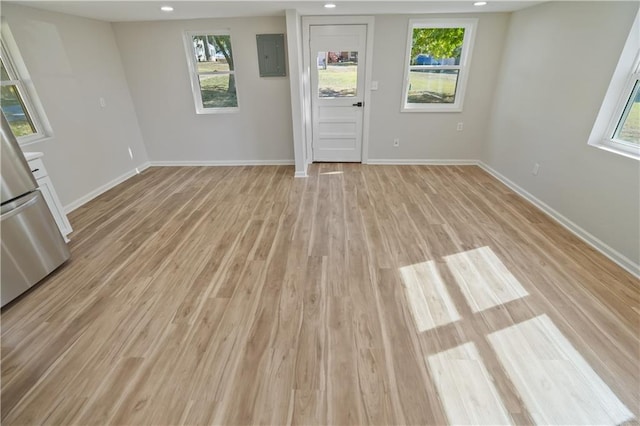 empty room with electric panel and light hardwood / wood-style flooring