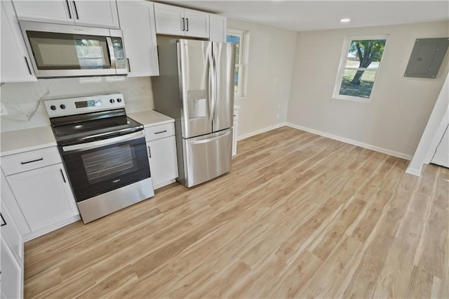 kitchen with appliances with stainless steel finishes, white cabinetry, electric panel, and light wood-type flooring