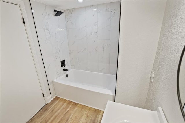 bathroom with tiled shower / bath combo and hardwood / wood-style flooring