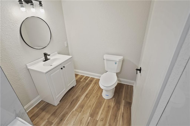 bathroom featuring vanity, hardwood / wood-style floors, and toilet