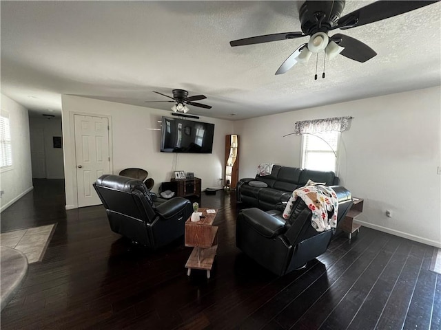 living room featuring ceiling fan, dark hardwood / wood-style flooring, and a textured ceiling