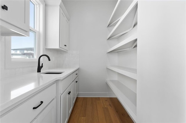 interior space featuring white cabinetry, sink, backsplash, and dark hardwood / wood-style floors