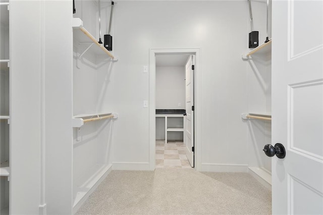 walk in closet featuring light carpet