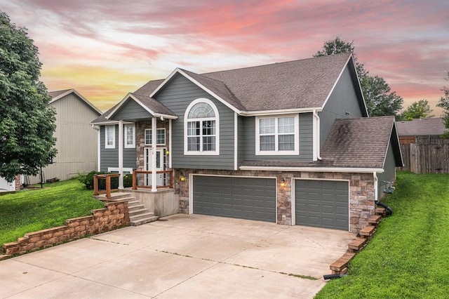 split foyer home featuring a garage and a lawn