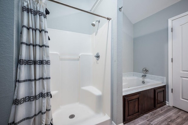 bathroom featuring plus walk in shower and wood-type flooring