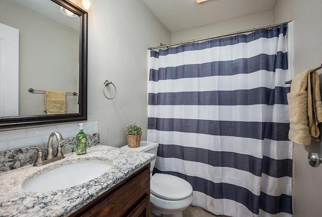 bathroom with walk in shower, vanity, toilet, and tasteful backsplash