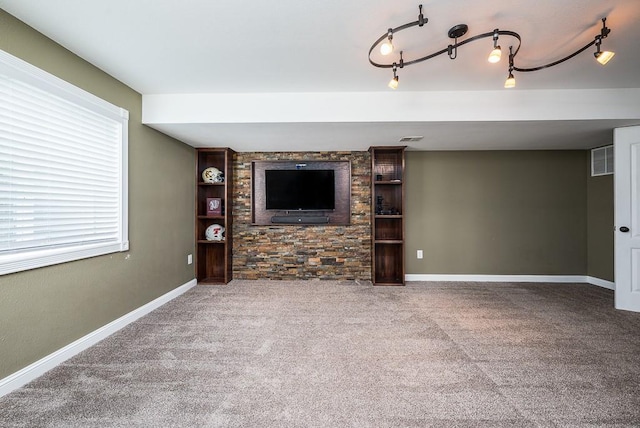 unfurnished living room featuring carpet floors and rail lighting