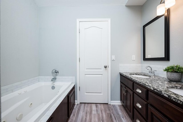 bathroom featuring vanity, hardwood / wood-style floors, and a bathtub