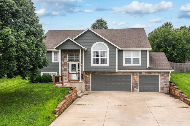 raised ranch with a front yard and a garage