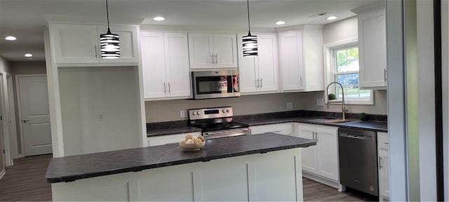 kitchen featuring sink, hanging light fixtures, a kitchen island, white cabinetry, and stainless steel appliances