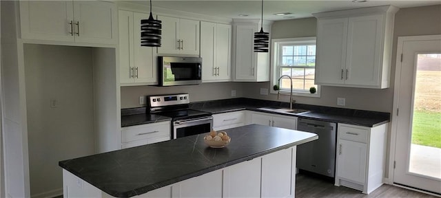 kitchen with appliances with stainless steel finishes, decorative light fixtures, and a healthy amount of sunlight