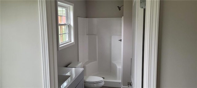 bathroom with walk in shower, vanity, toilet, and plenty of natural light