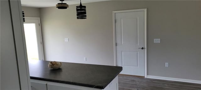 kitchen featuring decorative light fixtures, white cabinetry, and dark wood-type flooring