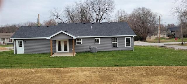 rear view of property with a lawn, french doors, and cooling unit