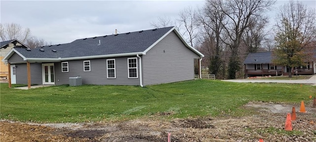 view of side of home featuring central AC unit and a yard