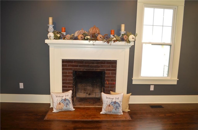 room details with hardwood / wood-style floors and a brick fireplace