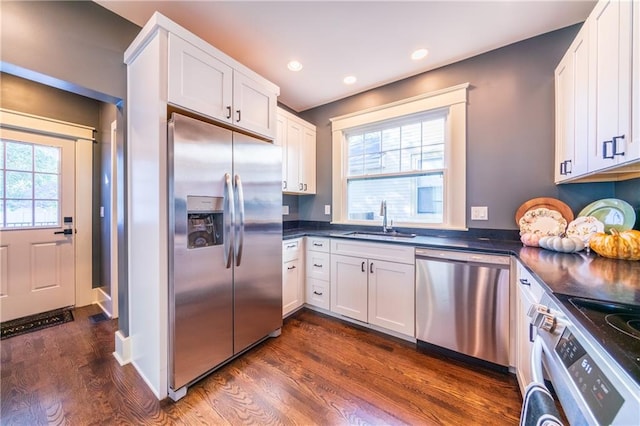 kitchen featuring stainless steel appliances, sink, dark hardwood / wood-style flooring, and white cabinets