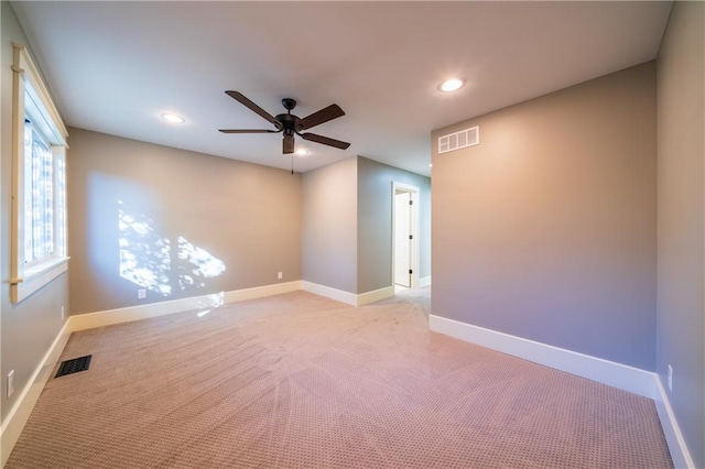 unfurnished room with light colored carpet and ceiling fan