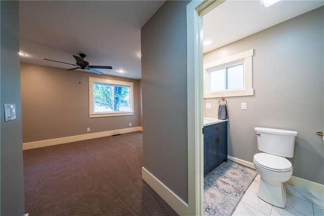 bathroom featuring vanity, toilet, and ceiling fan