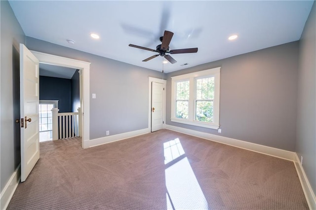 unfurnished room featuring light colored carpet and ceiling fan