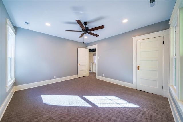 unfurnished bedroom featuring dark carpet and ceiling fan