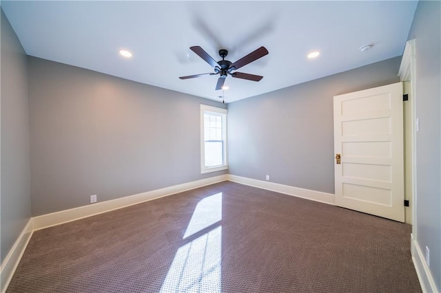 empty room with dark carpet and ceiling fan