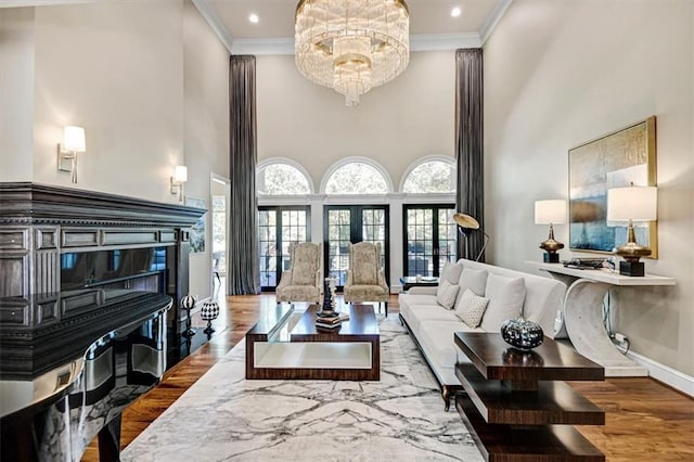 living room with ornamental molding, hardwood / wood-style floors, french doors, and a high ceiling