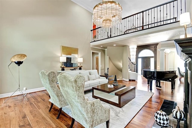 living room with light hardwood / wood-style flooring, a chandelier, and a high ceiling