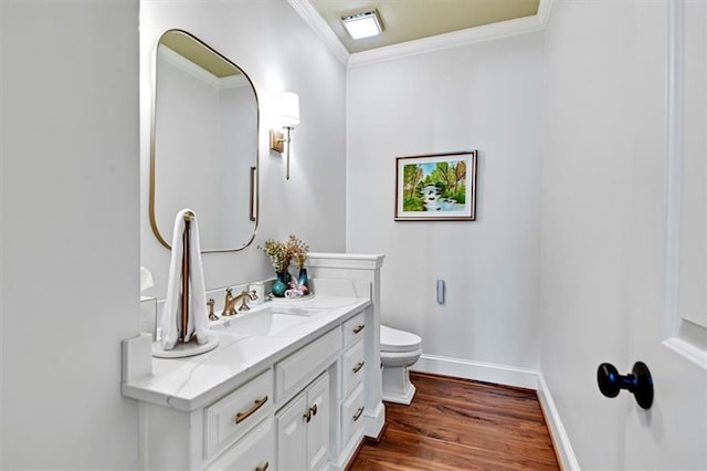 bathroom with toilet, ornamental molding, hardwood / wood-style flooring, and vanity