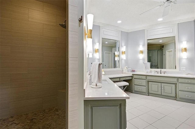 bathroom with vanity, ceiling fan, a tile shower, and tile patterned flooring