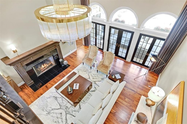 living room featuring french doors, wood-type flooring, and a high ceiling