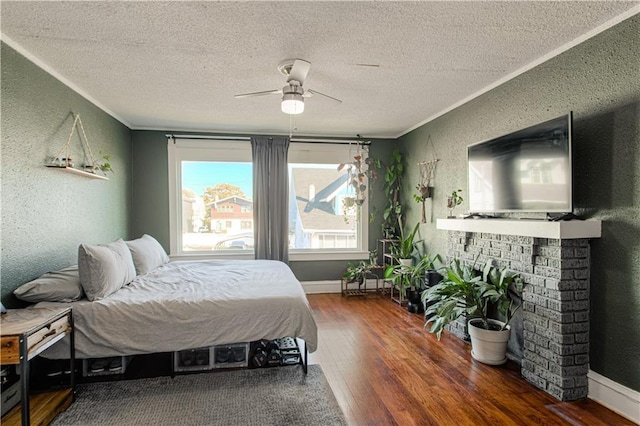 bedroom featuring ceiling fan, dark hardwood / wood-style flooring, a textured ceiling, and ornamental molding