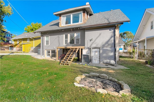 rear view of property with a lawn and central AC unit