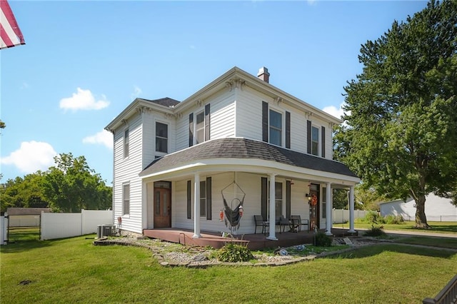 view of front facade featuring a front lawn, central air condition unit, and a porch