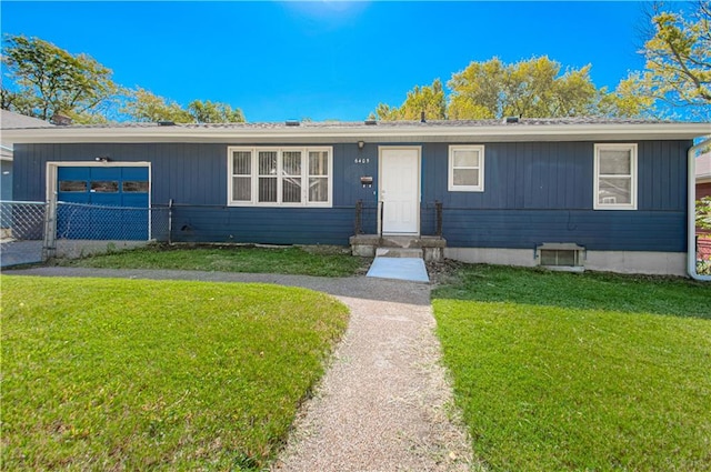 view of front of home with a front yard and a garage