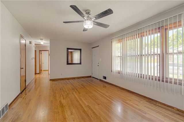 empty room with ceiling fan and light hardwood / wood-style flooring