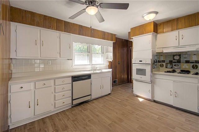 kitchen with decorative backsplash, white appliances, light hardwood / wood-style flooring, and white cabinetry