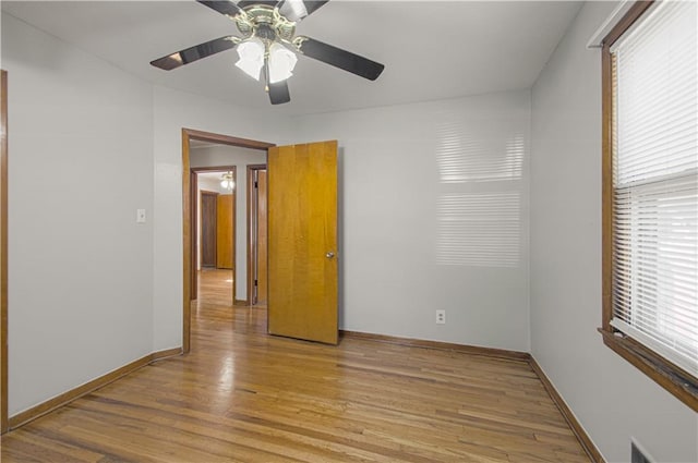 unfurnished room featuring light wood-type flooring, plenty of natural light, and ceiling fan