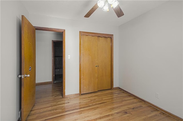 unfurnished bedroom featuring a closet, light hardwood / wood-style floors, and ceiling fan