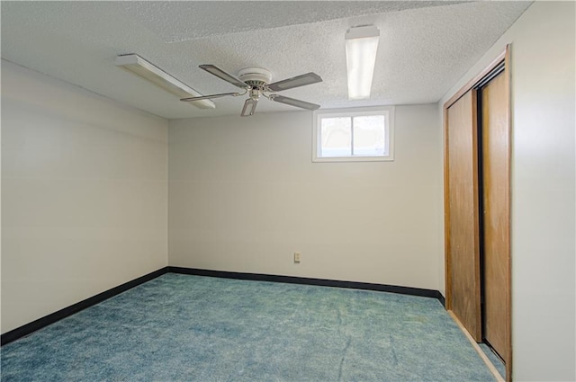 carpeted spare room featuring ceiling fan and a textured ceiling