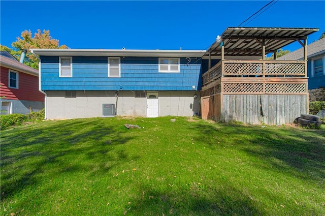 rear view of property featuring a lawn and a wooden deck