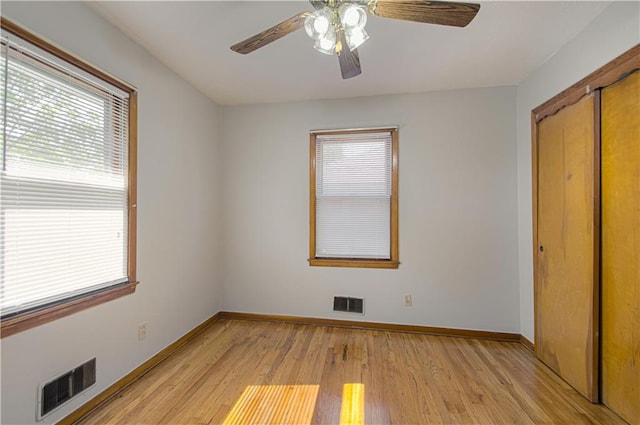 unfurnished bedroom featuring light hardwood / wood-style floors, a closet, and ceiling fan