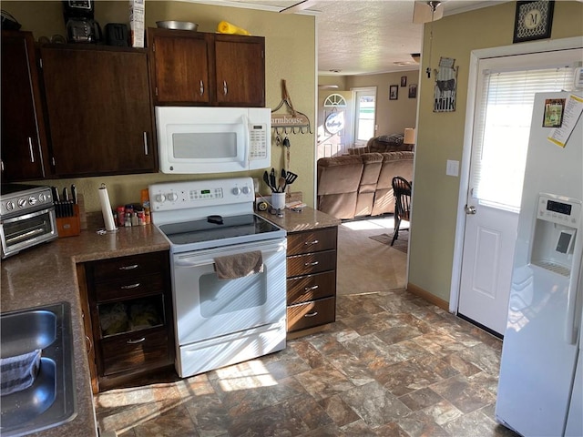 kitchen with white appliances, dark brown cabinets, and a wealth of natural light