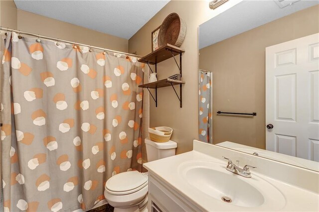 bathroom with a shower with shower curtain, vanity, and toilet