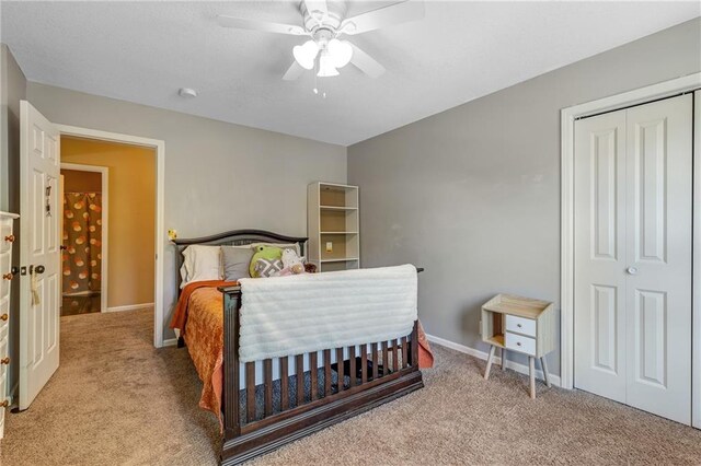 carpeted bedroom with a closet, ceiling fan, and baseboards