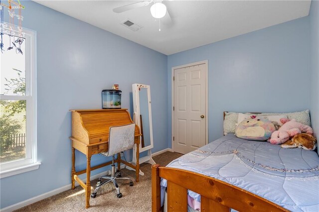 carpeted bedroom with visible vents, ceiling fan, and baseboards