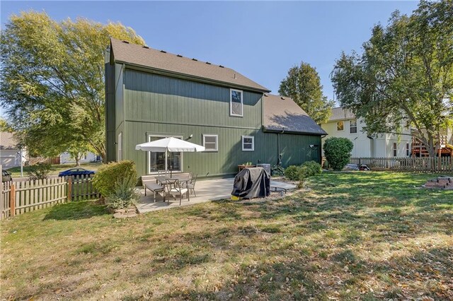 rear view of property with a yard, a patio, and fence