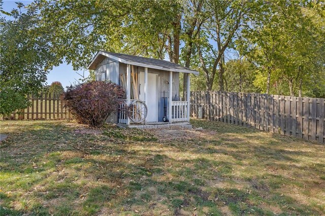 view of outdoor structure featuring a fenced backyard and an outbuilding